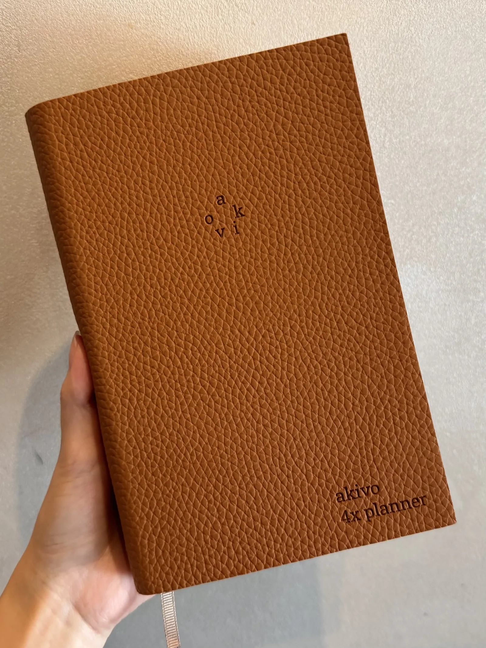 Camel Brown AKIVO 4X Planner held in one hand